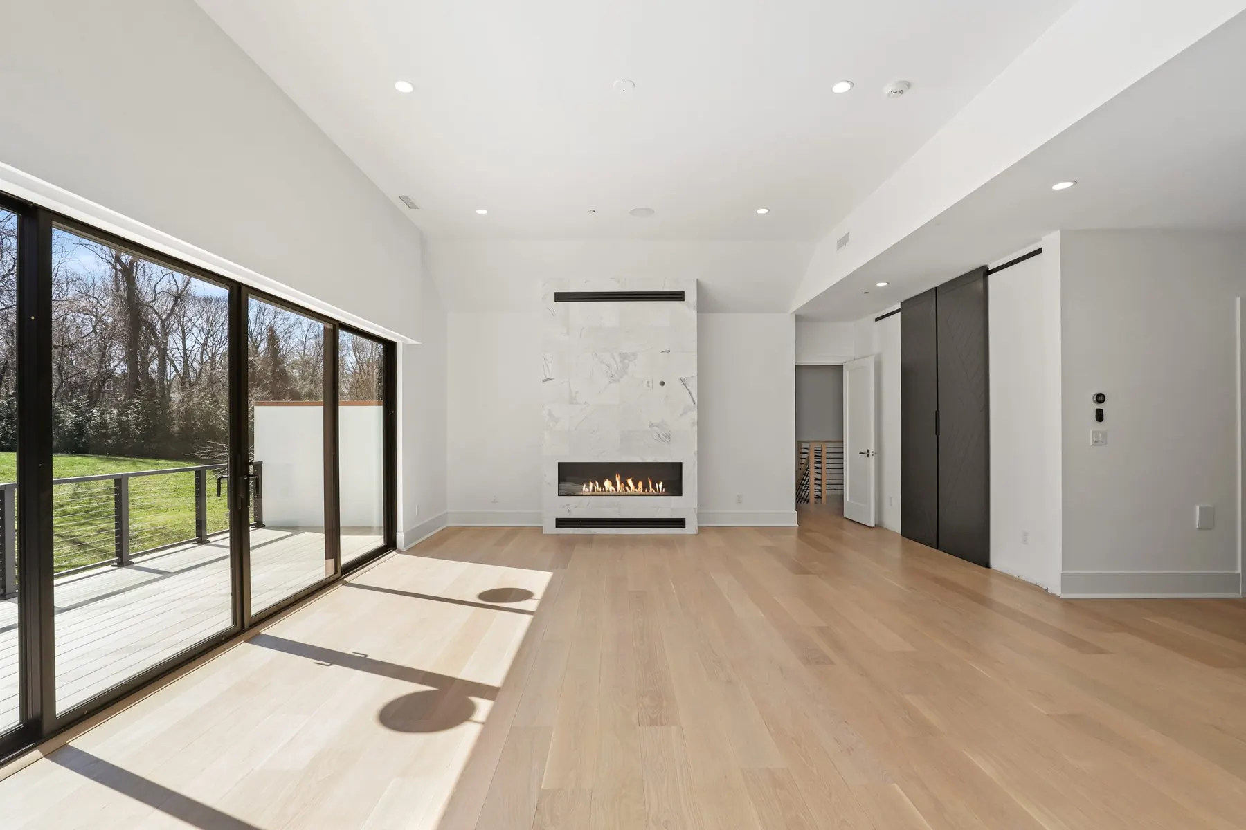 Primary suite with a marble fireplace surround and wide-plank oak floors